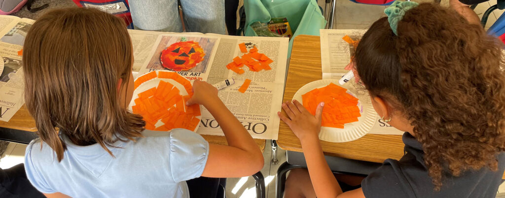 Two children work on an art project together